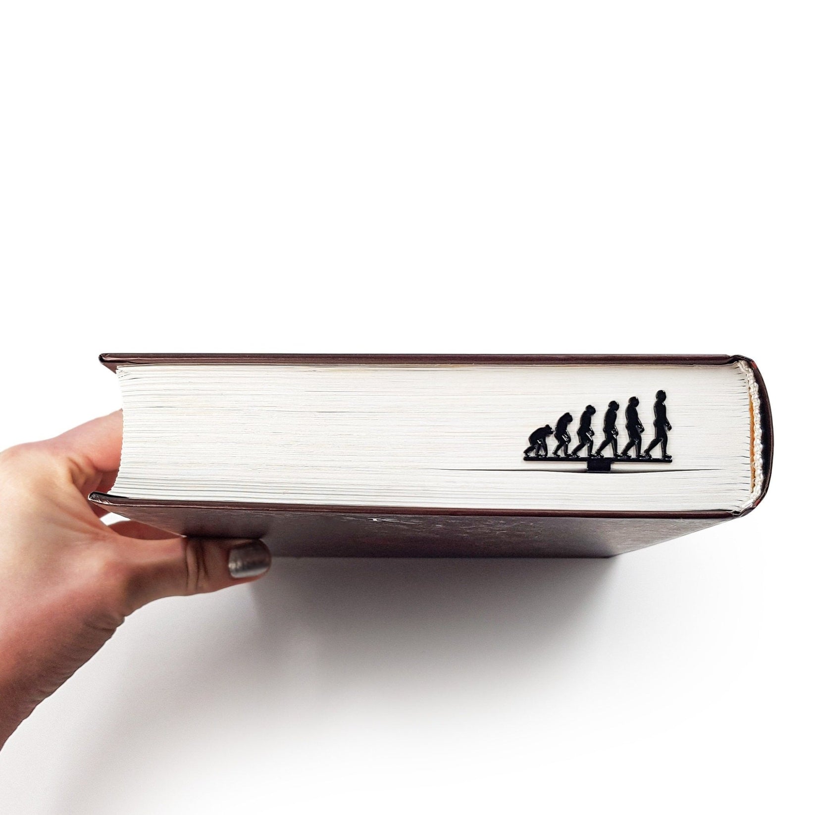 Evolution metal bookmark in a closed book, only its top showing above the pages