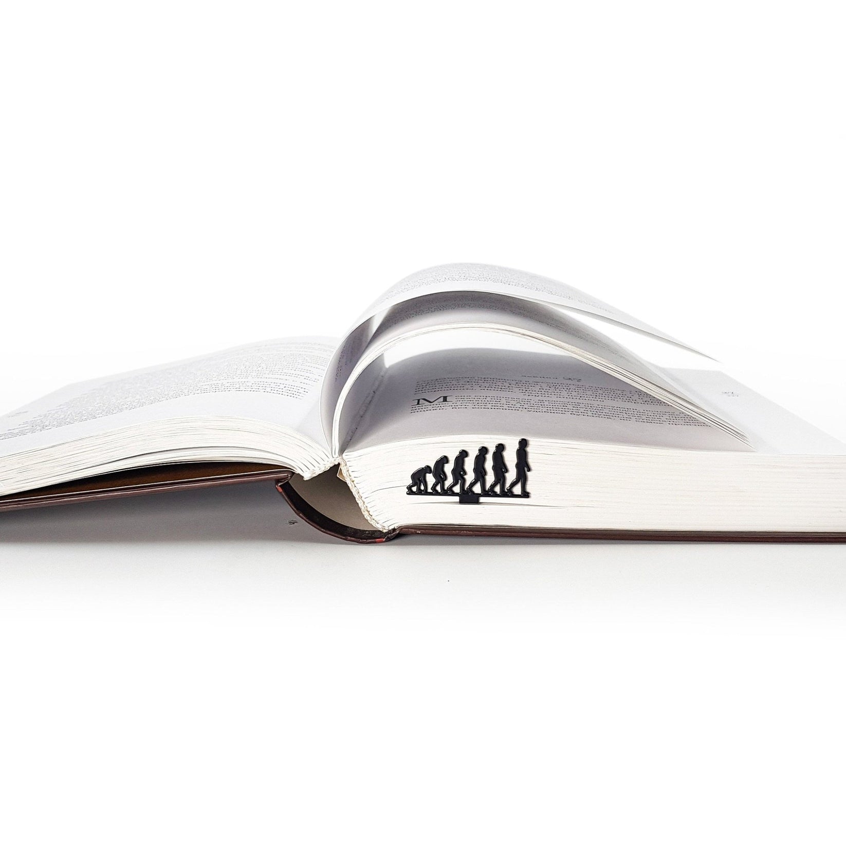 Evolution metal bookmark resting on the pages of an open book