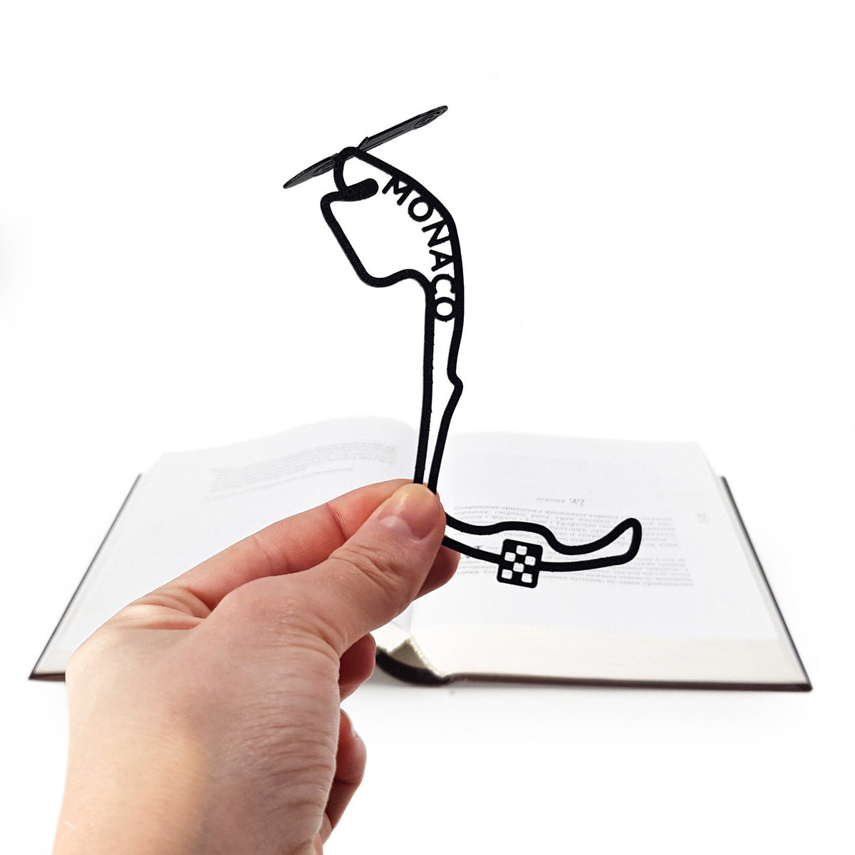 F1 Monaco Race Car metal bookmark held in a hand above an open book