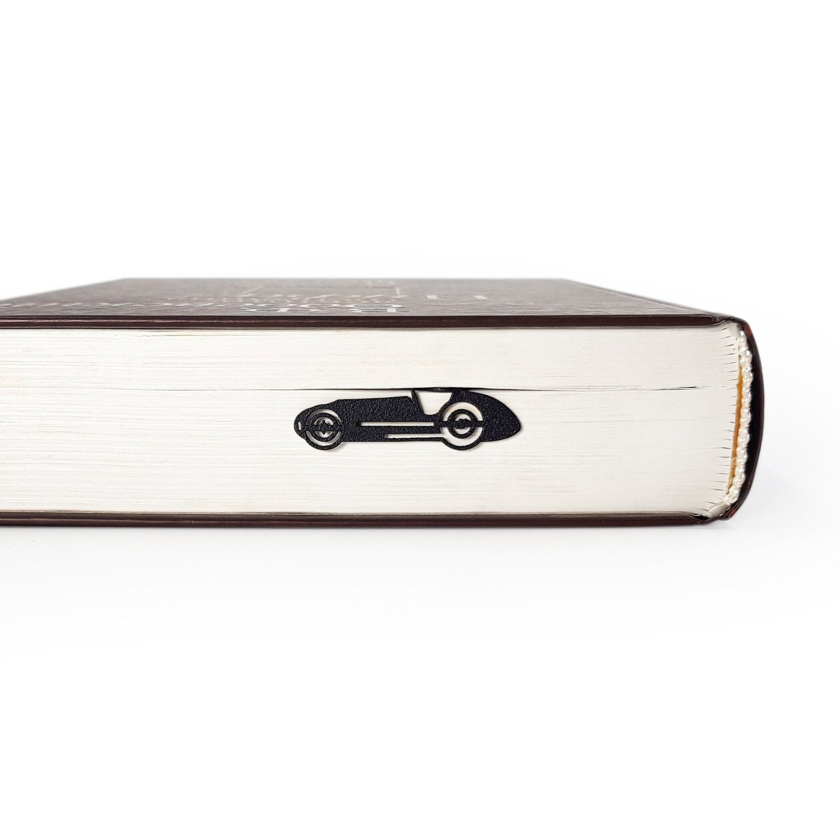 F1 Monaco Race Car metal bookmark in a closed book, only its top showing above the pages