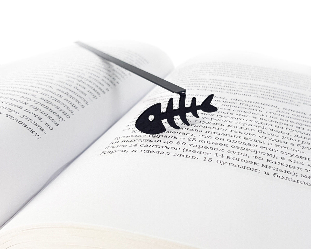 Fishbone metal bookmark set into the gutter of an open book