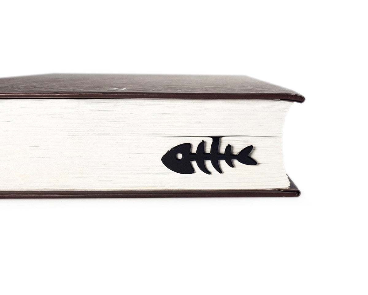 Fishbone metal bookmark seen from the edge of a closed book