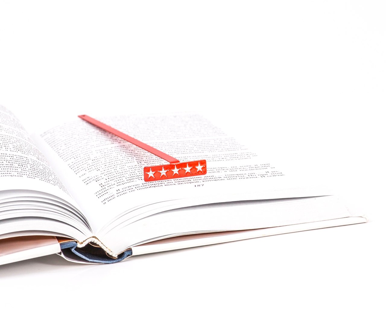 Five Star Bestseller metal bookmark in red resting on the pages of an open book