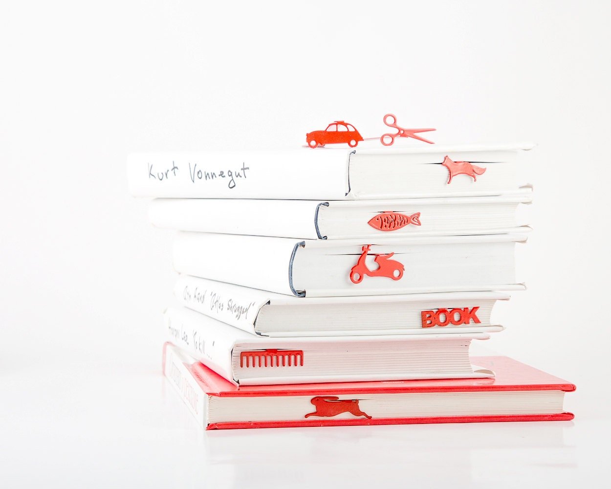 Five Star Bestseller metal bookmark in red shown with a stack of books