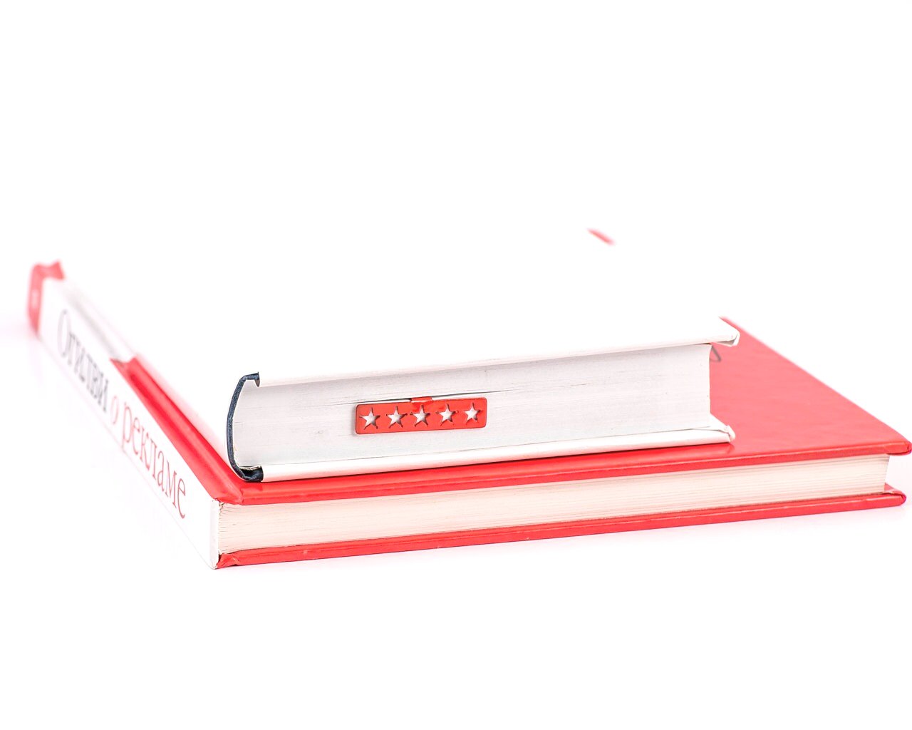 Five Star Bestseller metal bookmark in red seen from the edge of a closed book