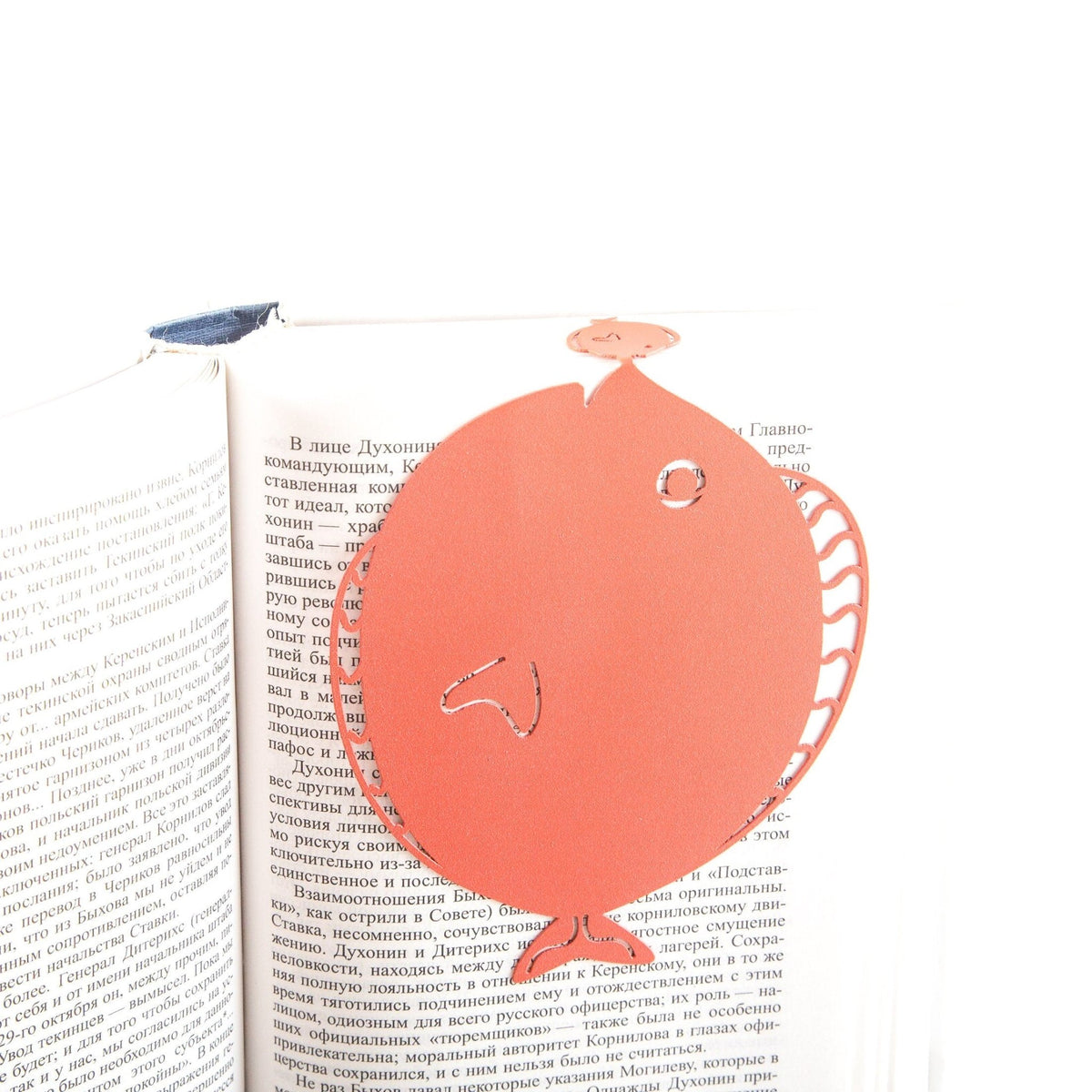 Flounder metal bookmark in red set into the gutter of an open book