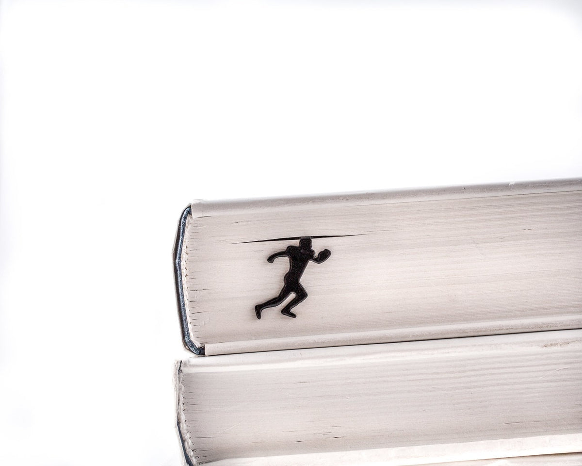 Football Player metal bookmark in a closed book, only its top showing above the pages