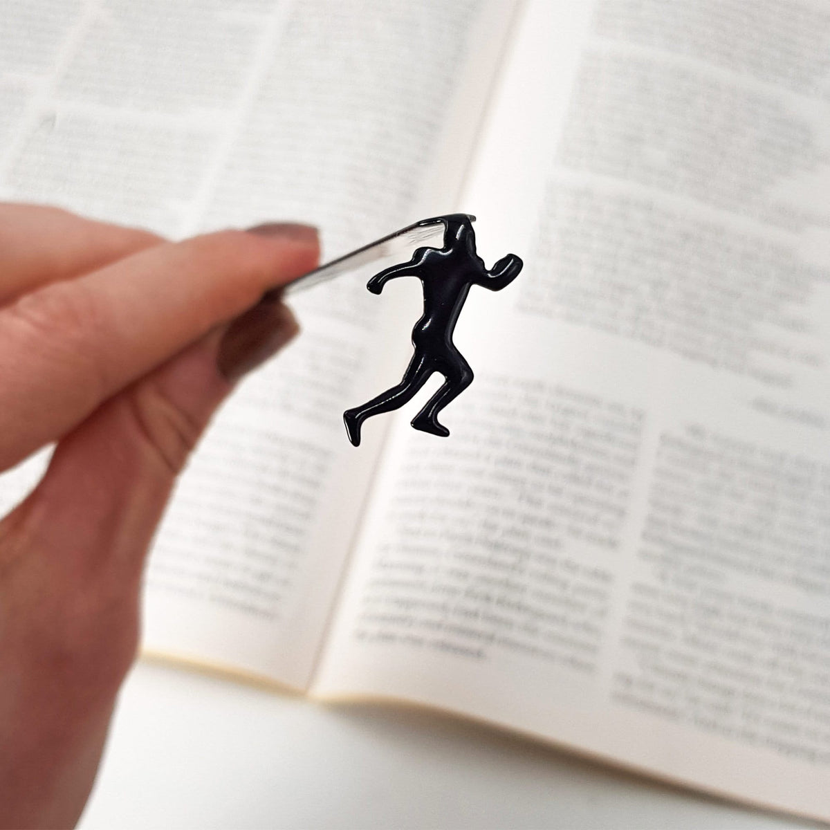 Football Player metal bookmark held up beside an open book