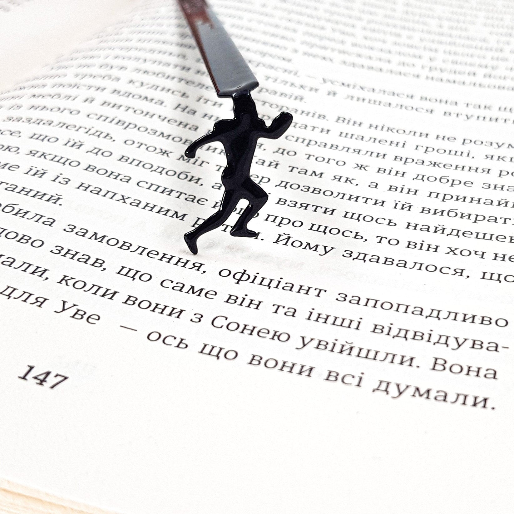Football Player metal bookmark lying across the pages of an open book