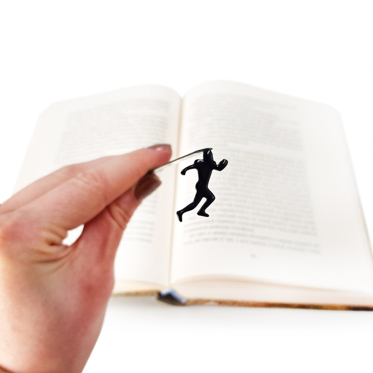 Football Player metal bookmark held in a hand above an open book