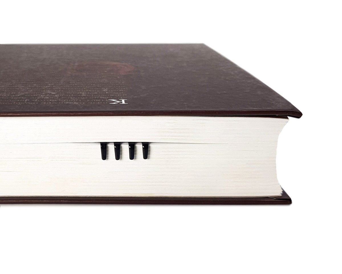 Fork metal bookmark in a closed book, only its top showing above the pages