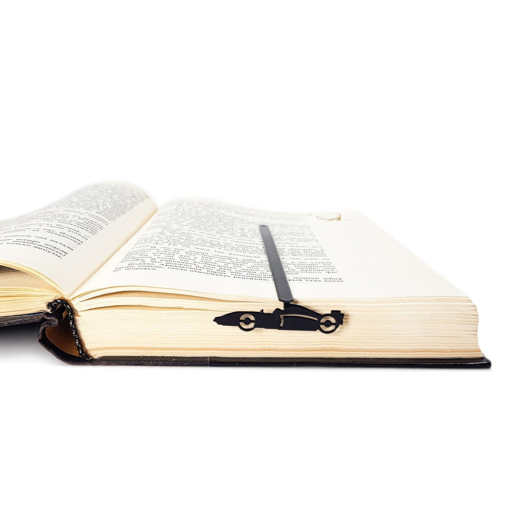 Formula One Indy Car metal bookmark marking a page in an open book