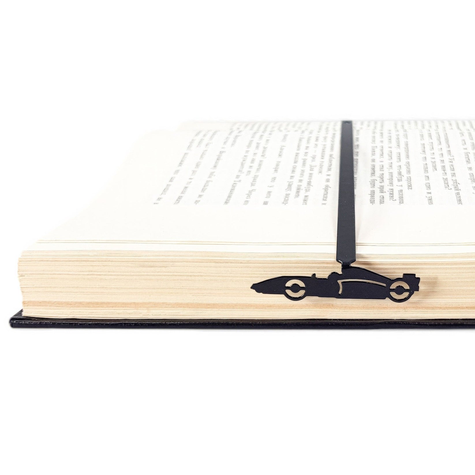 Formula One Indy Car metal bookmark resting on the pages of an open book