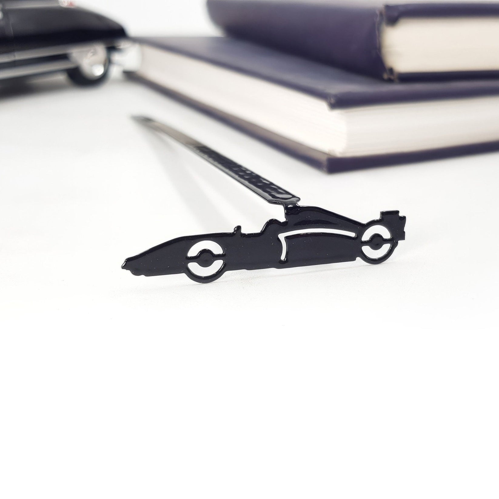 Formula One Indy Car metal bookmark shown with a stack of books