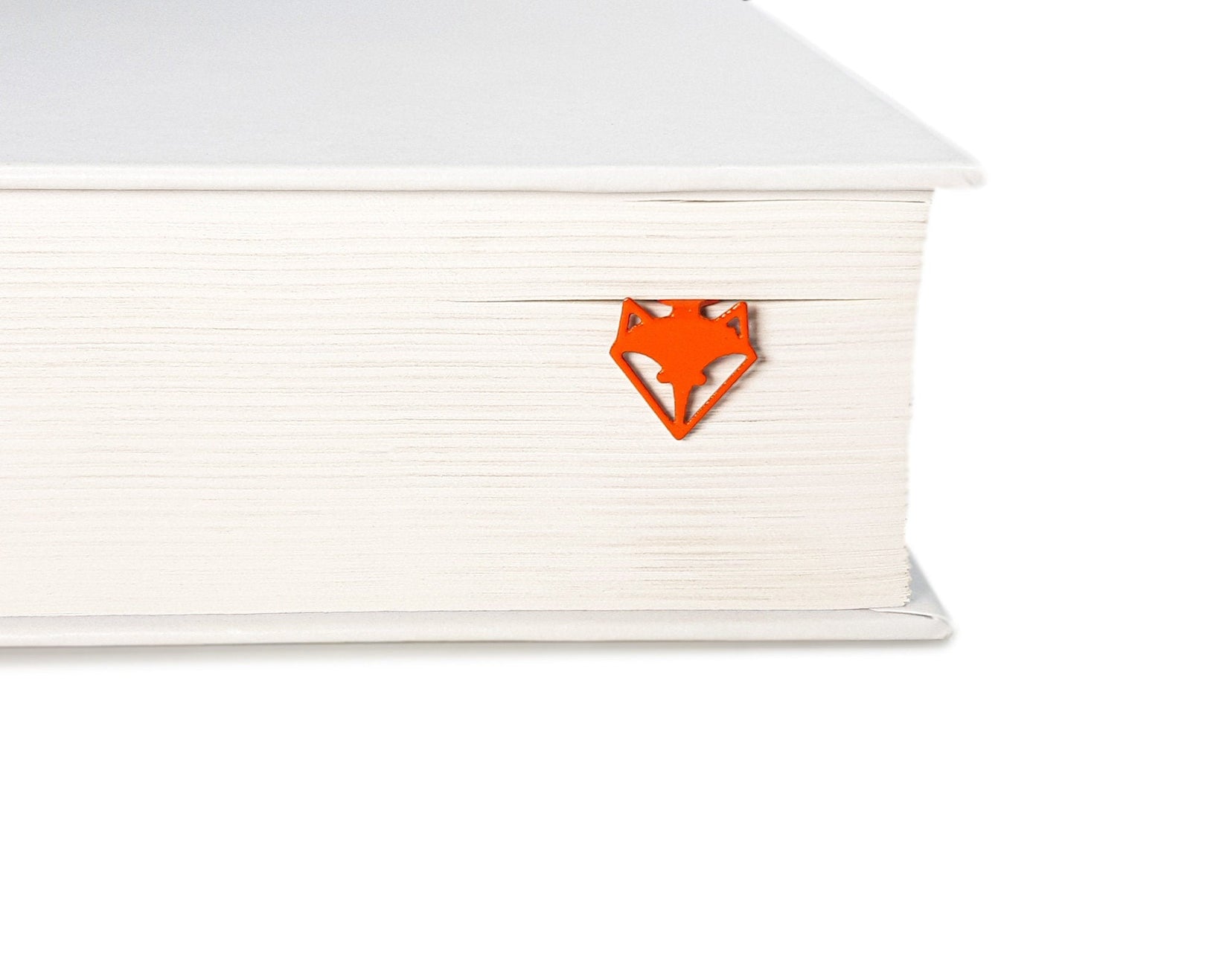 Fox Head metal bookmark in red clipped in a closed book, viewed from the side