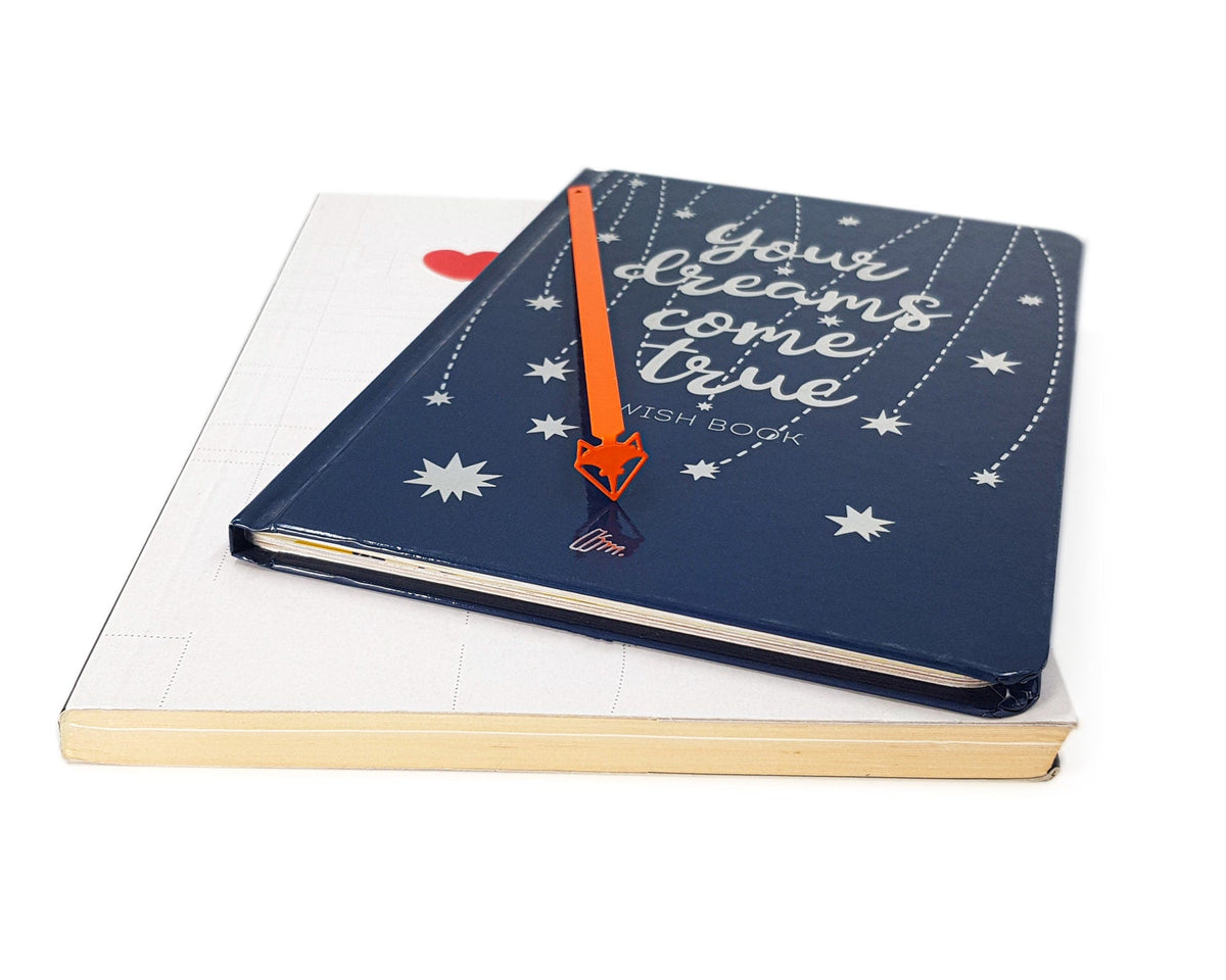 Fox Head metal bookmark marking a page in a notebook