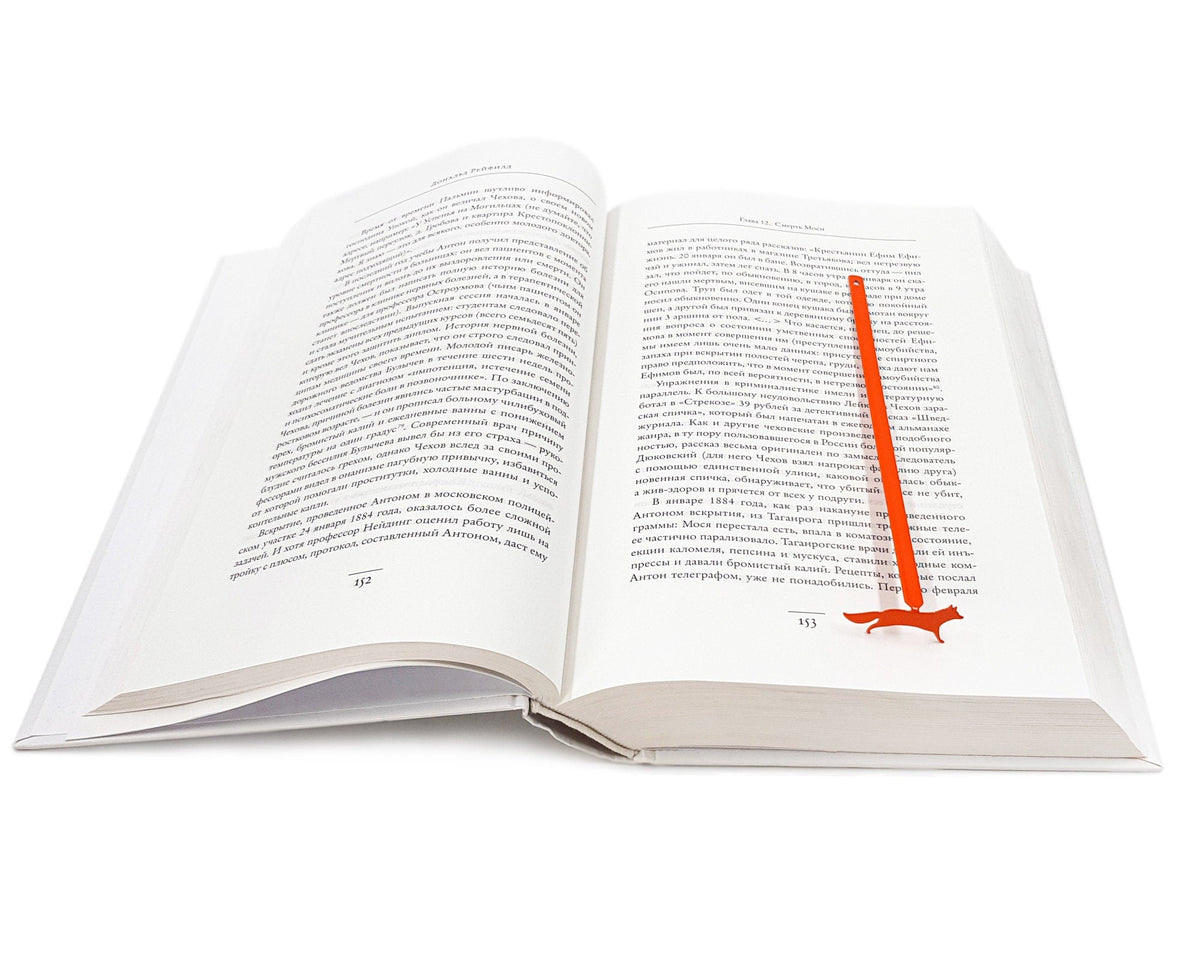 Fox on the Run metal bookmark in red set into the gutter of an open book