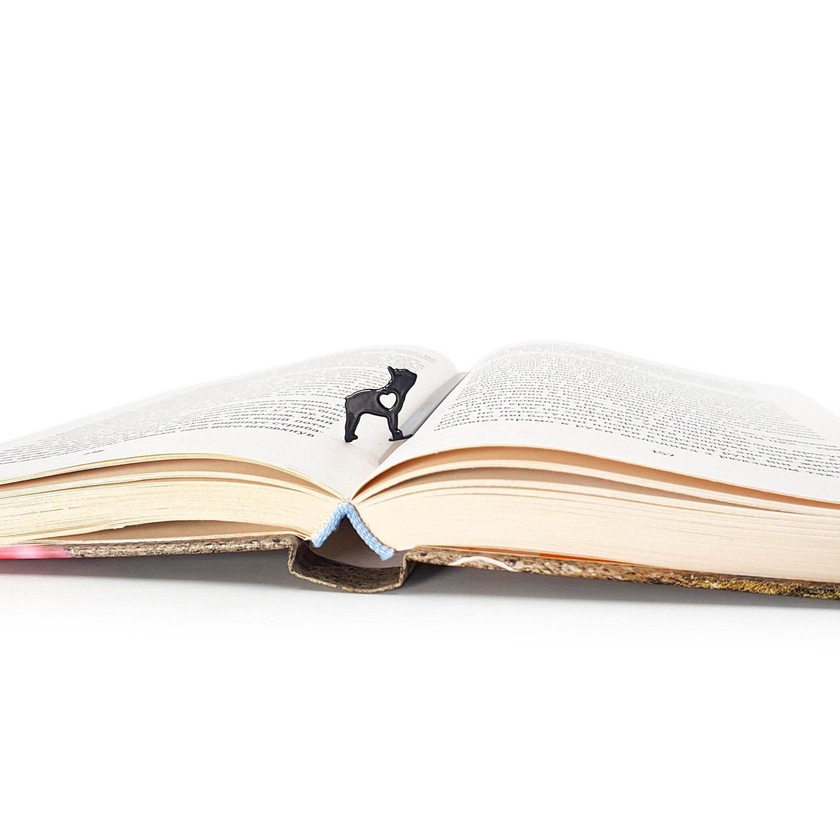 French Bulldog Love metal bookmark lying across the pages of an open book