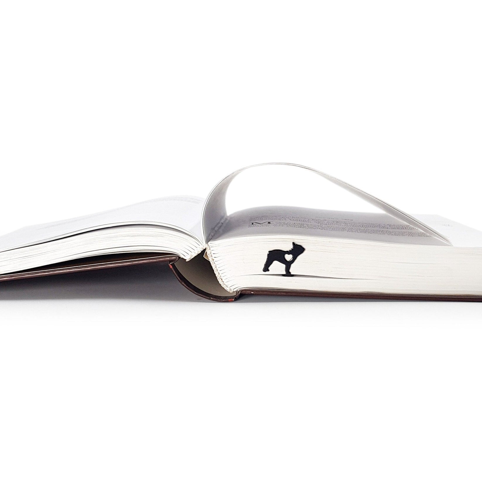 French Bulldog Love metal bookmark in a closed book, only its top showing above the pages