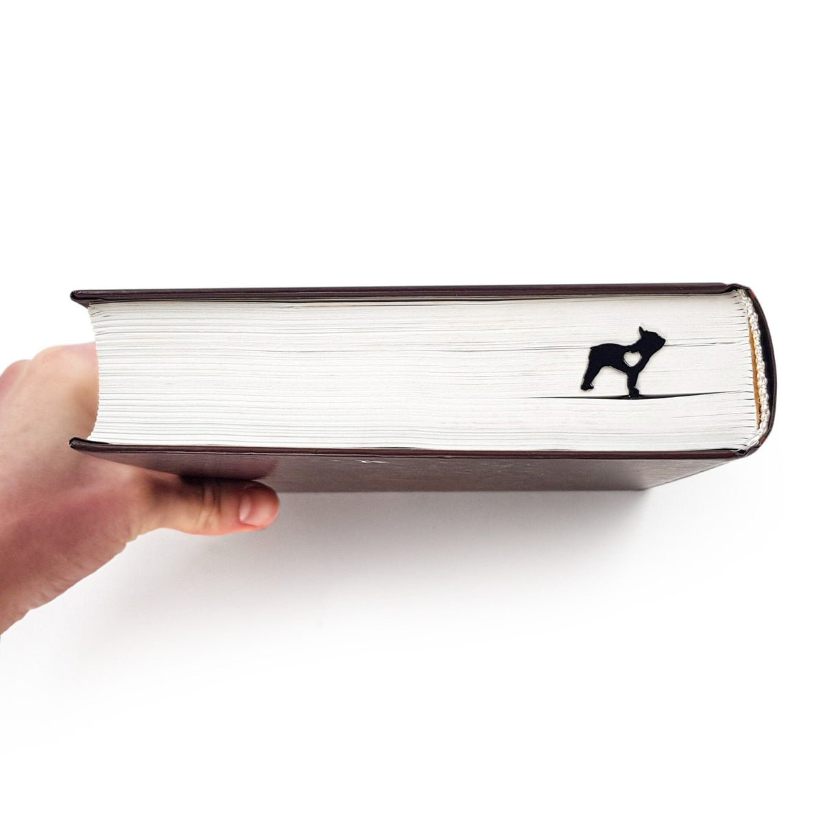 French Bulldog Love metal bookmark held up beside an open book