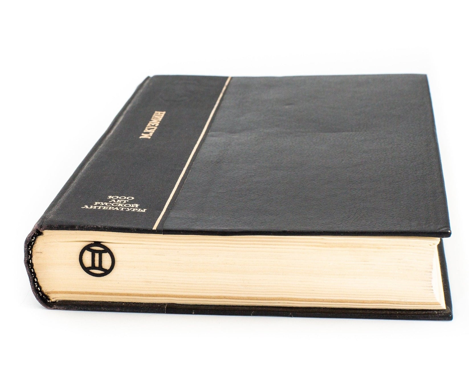 Gemini metal bookmark in a closed book, only its top showing above the pages
