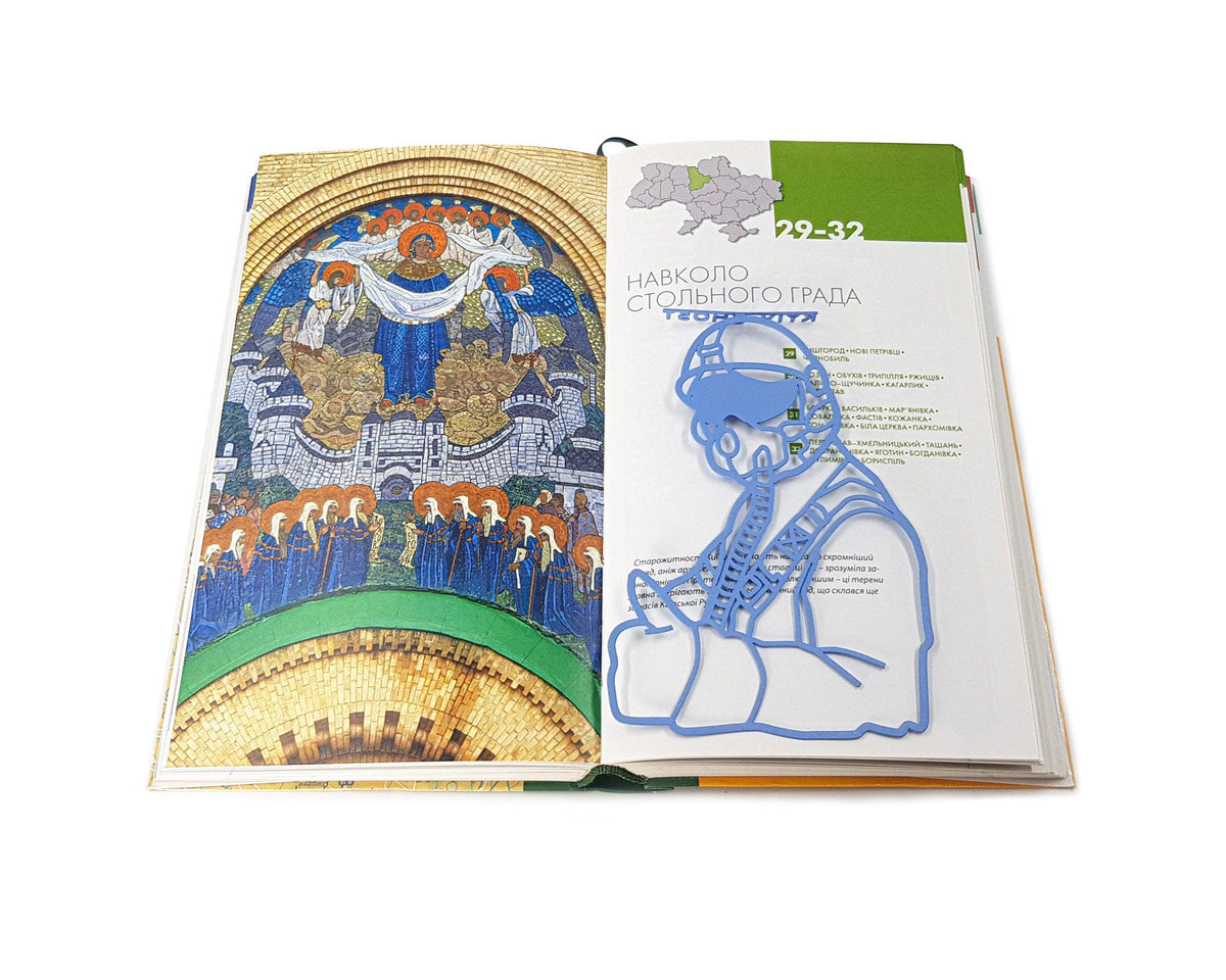 Ghost of Kyiv metal bookmark on an illustrated page
