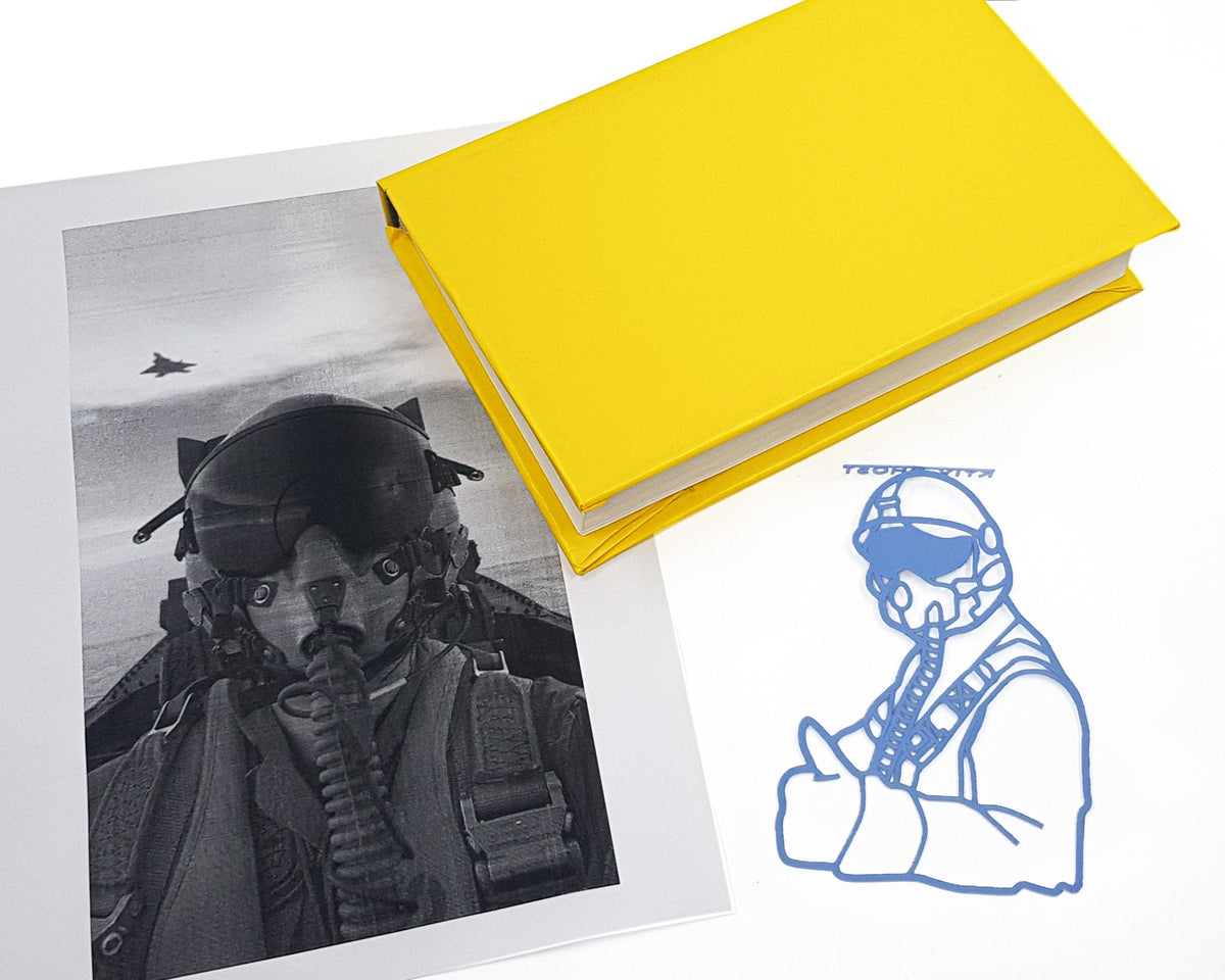 Ghost of Kyiv metal bookmark marking a page in an illustrated book