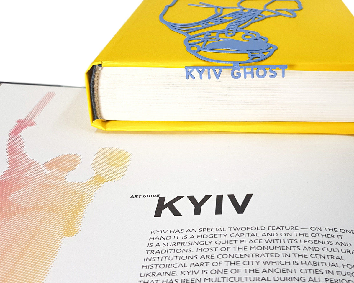 Ghost of Kyiv metal bookmark in blue seen from the edge of a closed book