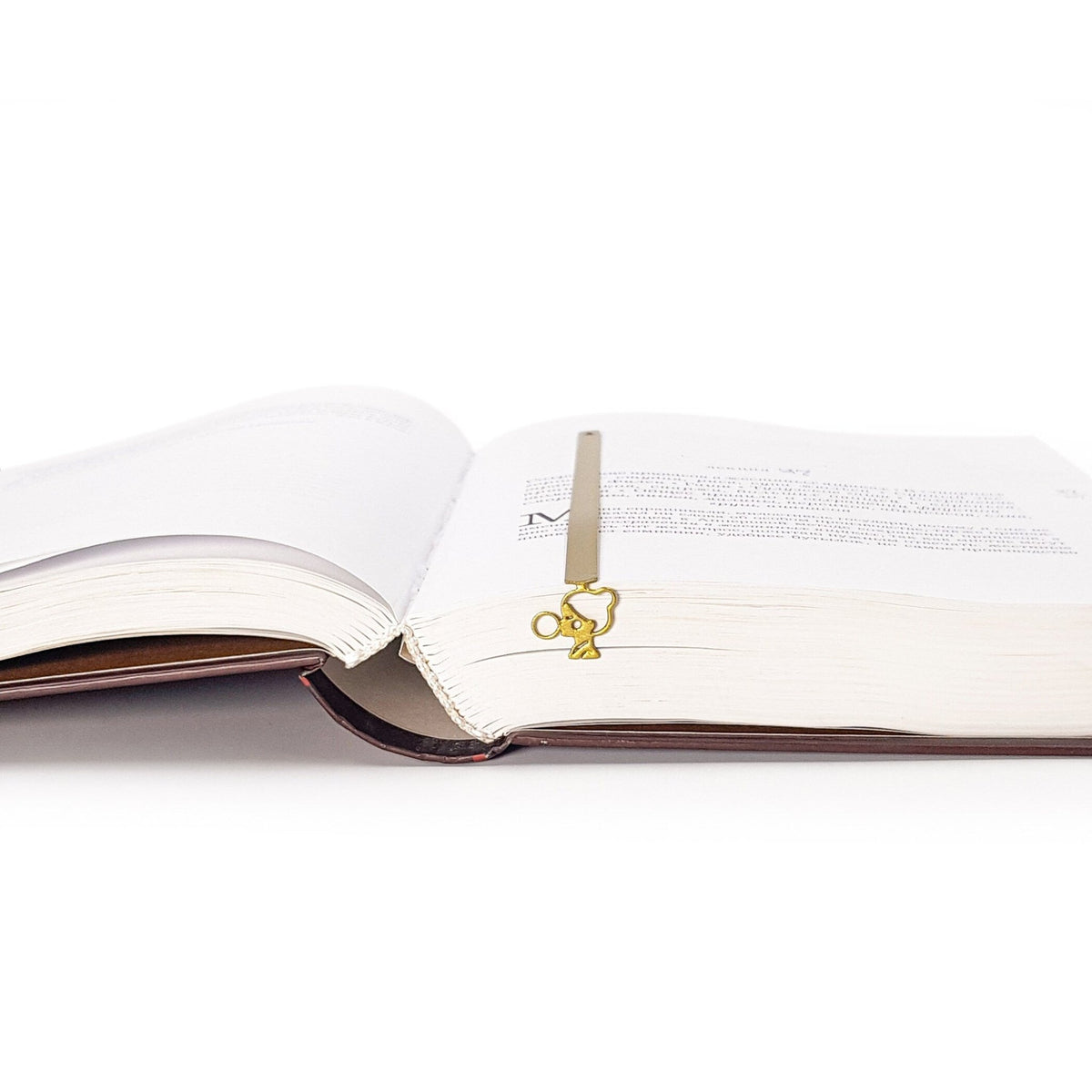 Girl with a Bubble Gum metal bookmark in gold marking a page in an open book