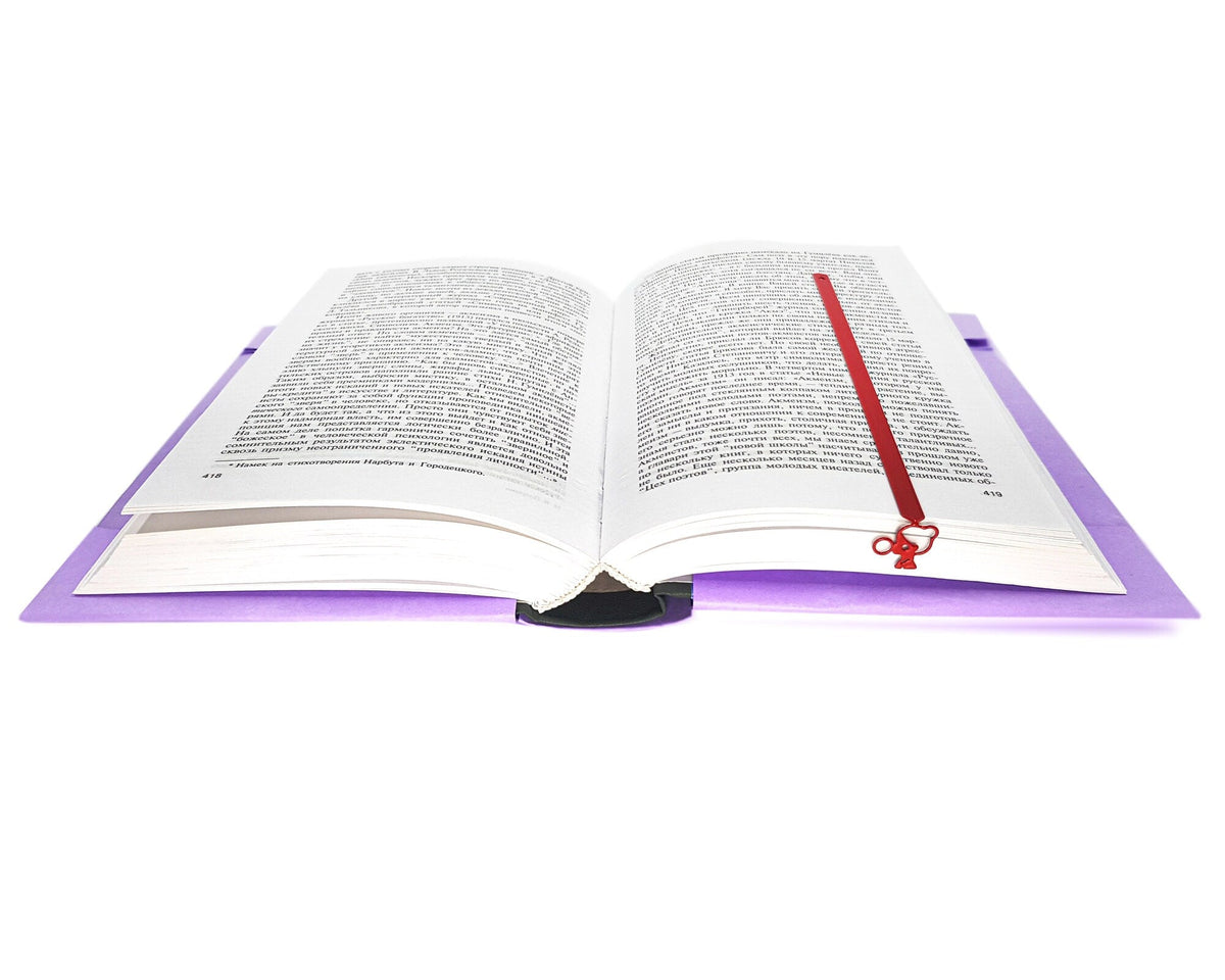 Girl with a Bubble Gum metal bookmark in red resting on the pages of an open book