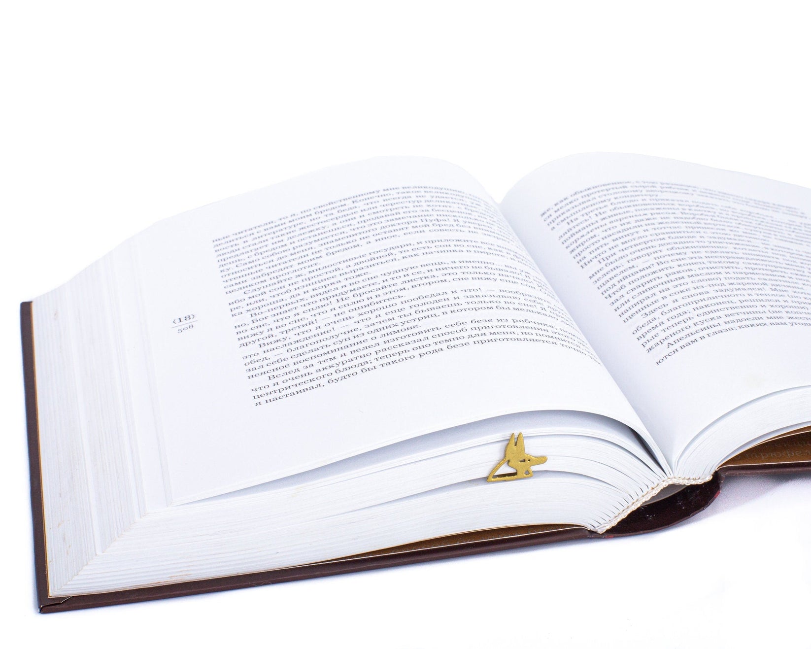 God of Death Anubis metal bookmark in gold resting on the pages of an open book