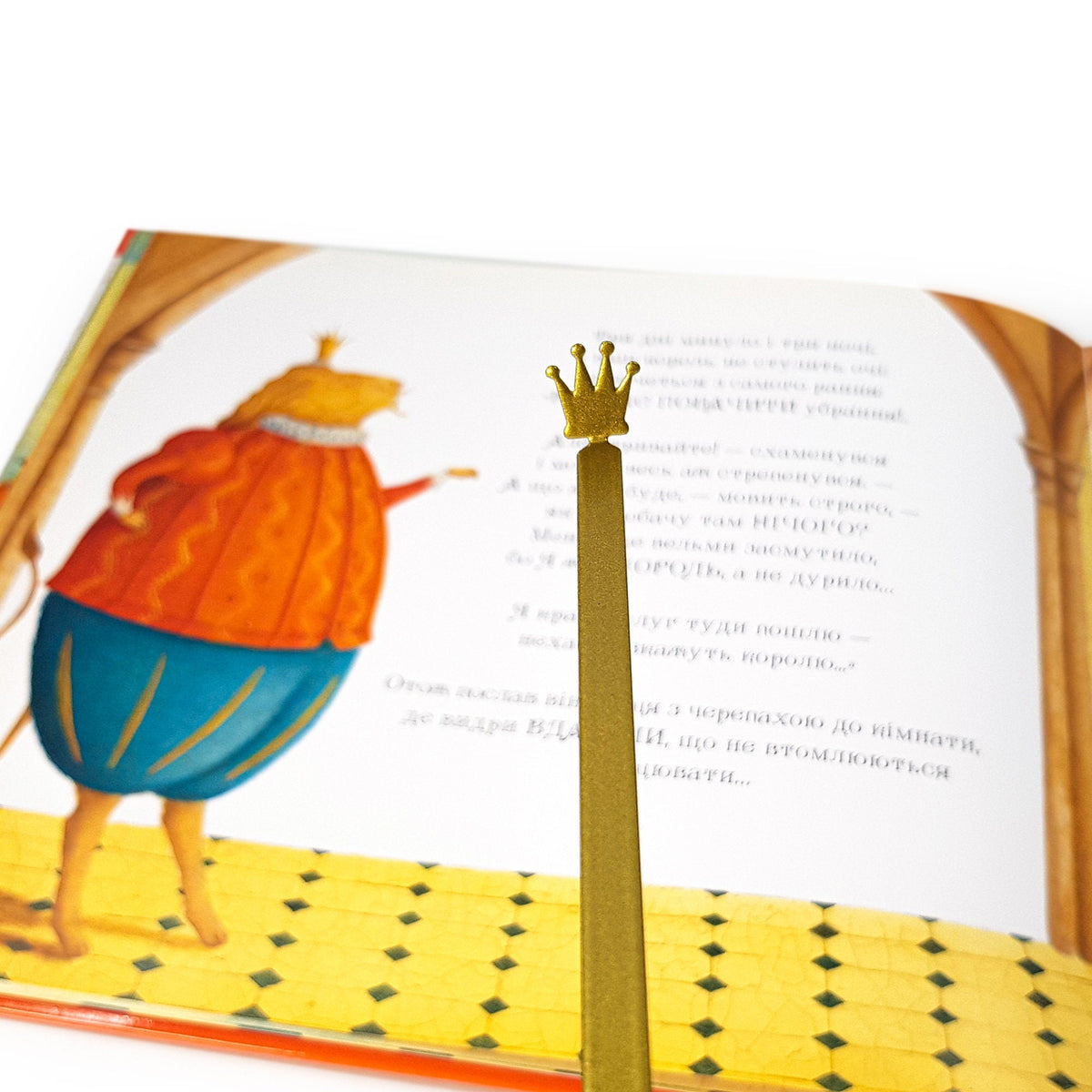 Golden Crown metal bookmark placed on a colour illustration