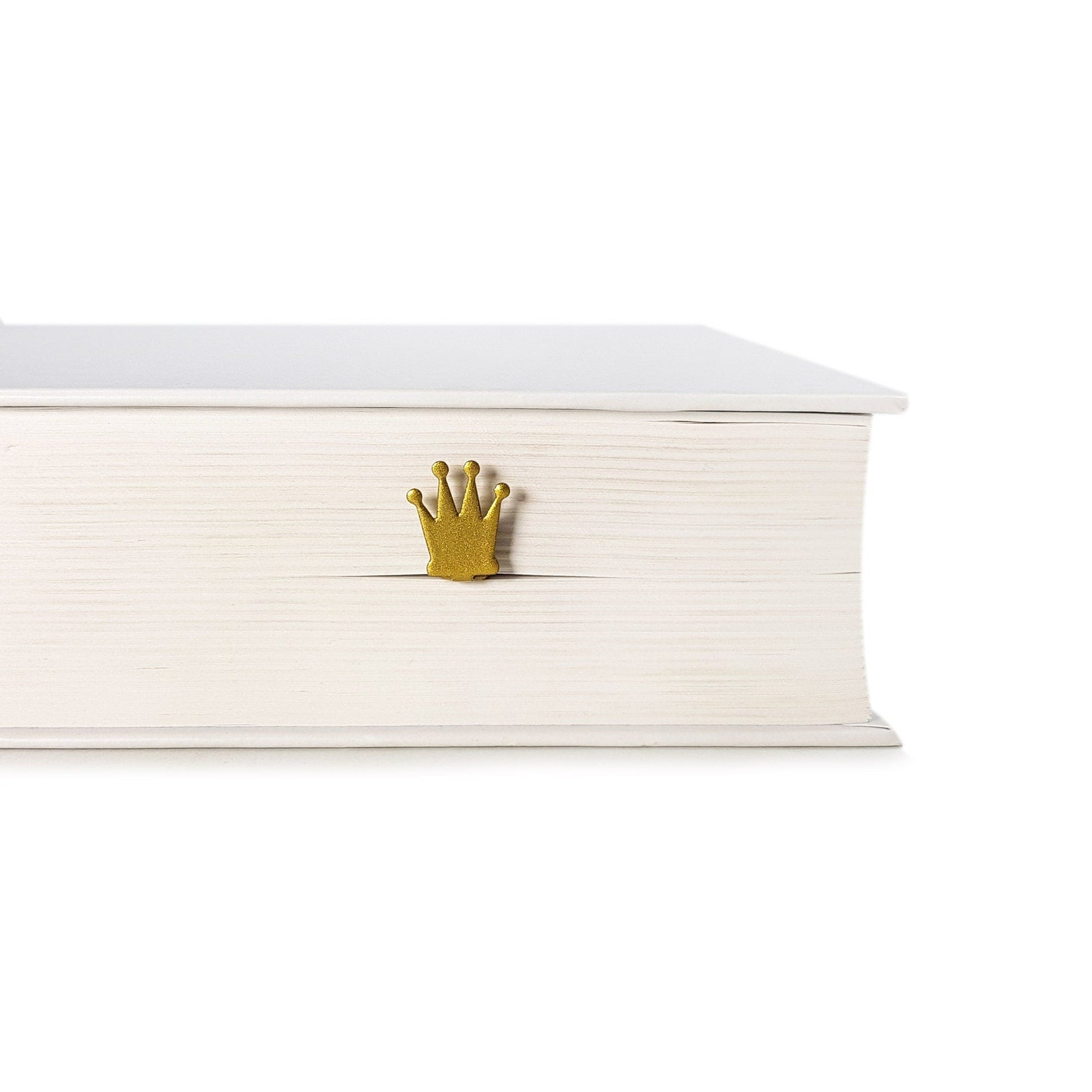 Golden Crown metal bookmark in gold seen from the edge of a closed book