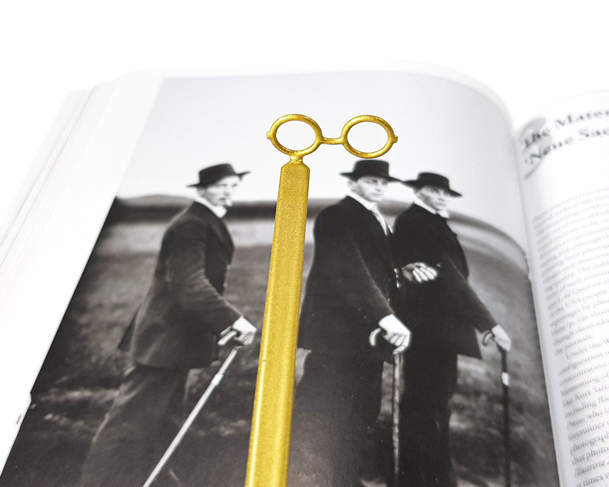 Golden Round Glasses metal bookmark placed on a colour illustration