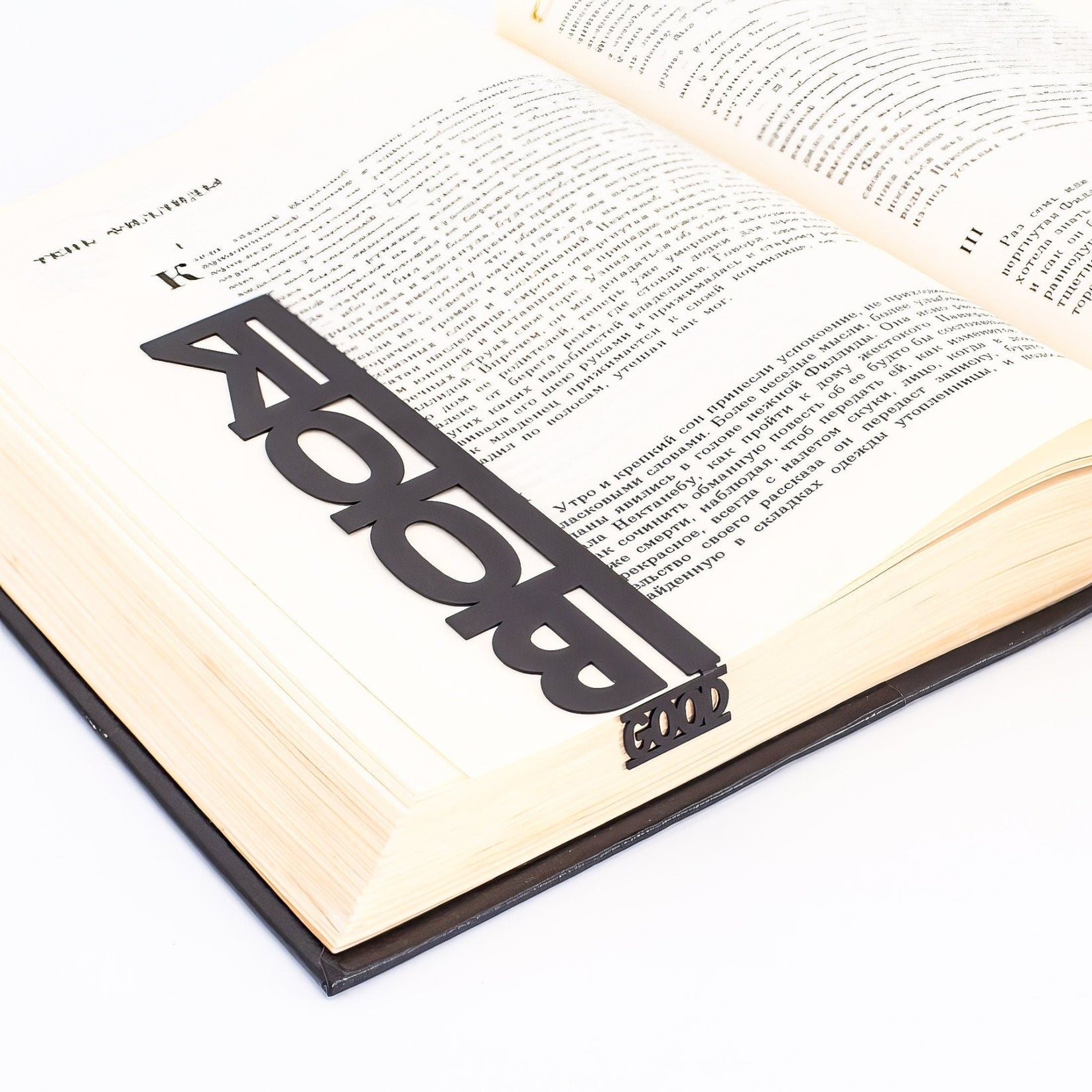 Good Book metal bookmark lying across the pages of an open book