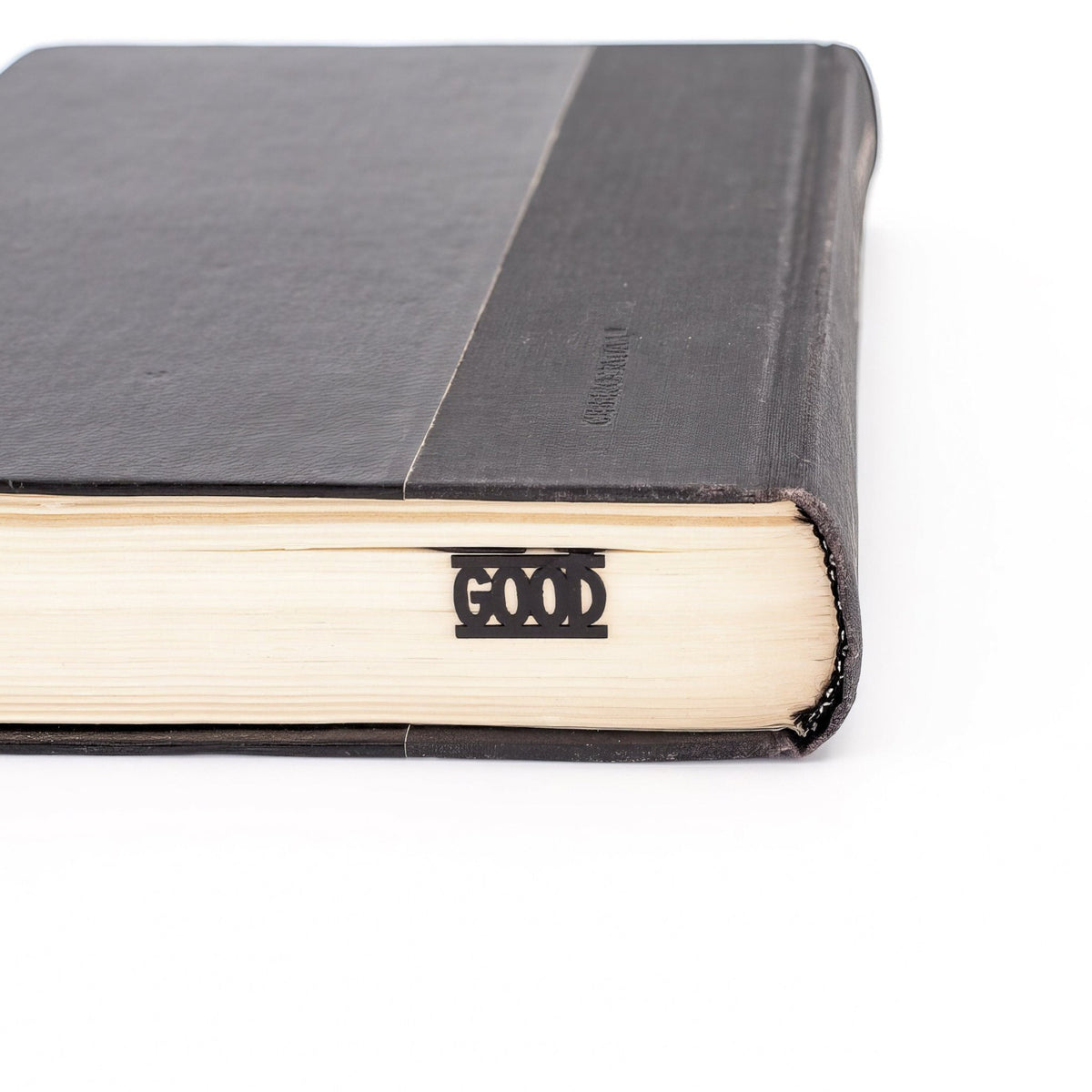 Good Book metal bookmark in a closed book, only its top showing above the pages