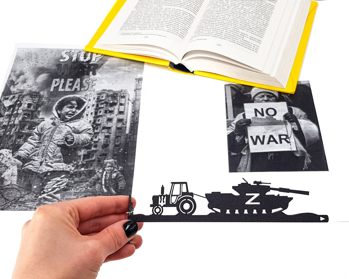 Good Evening We Are from Ukraine metal bookmark held in a hand above an open book