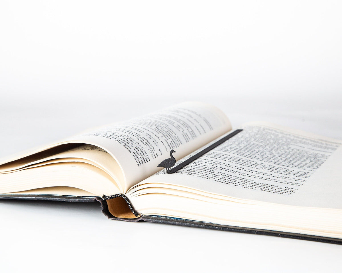 Goose metal bookmark resting on the pages of an open book