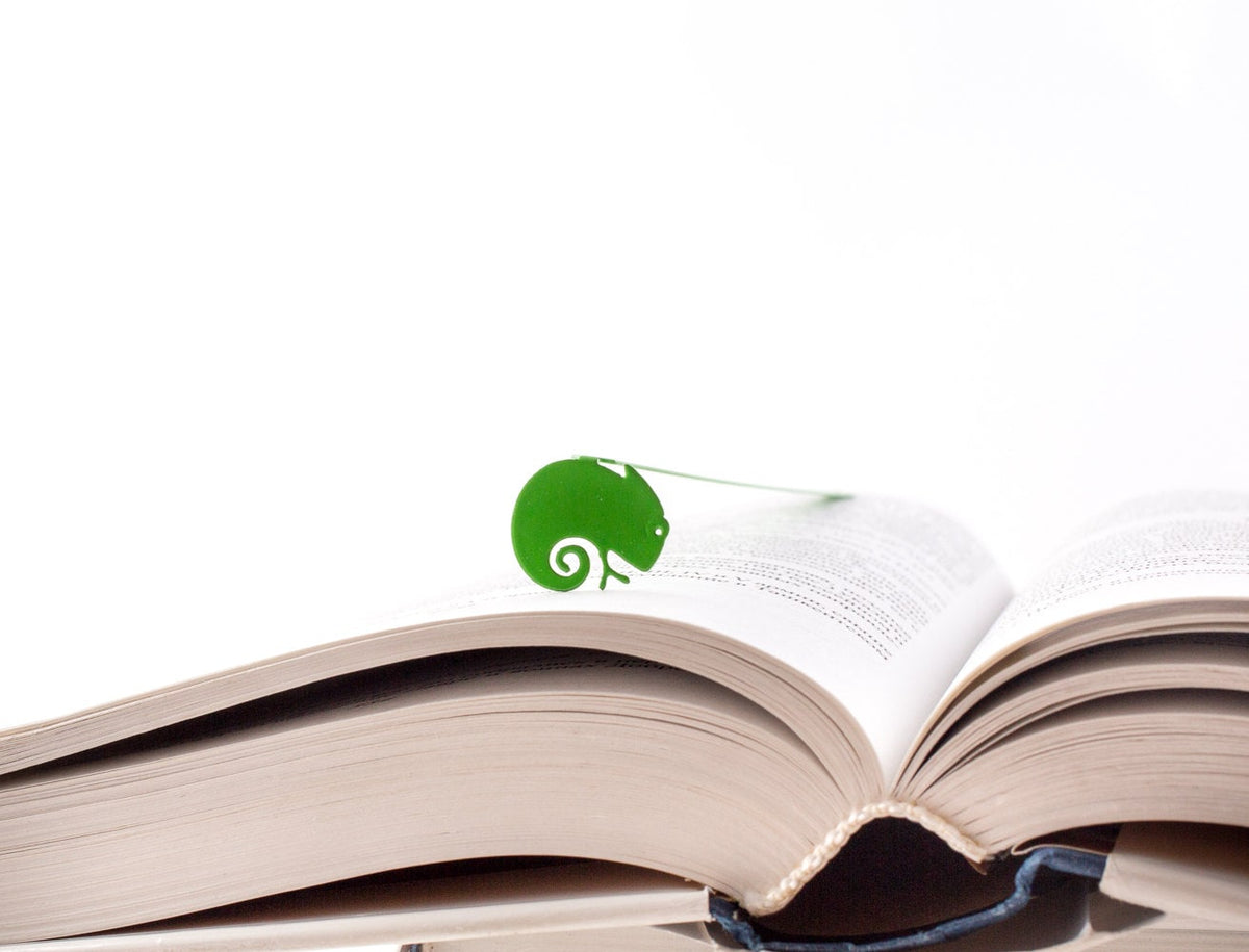 Green Lizard metal bookmark in green marking a page in an open book