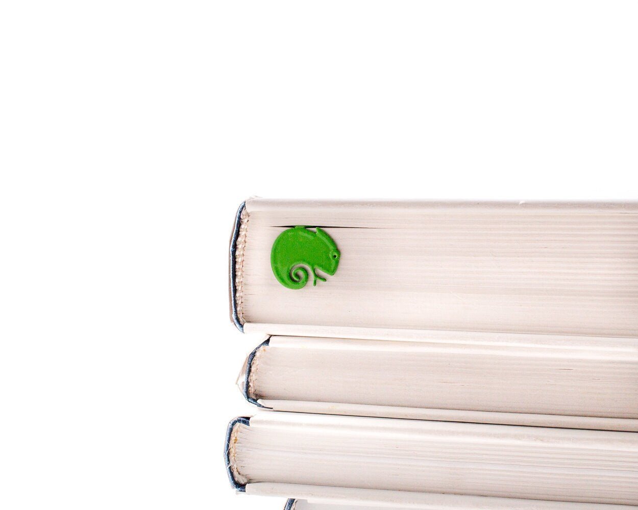 Green Lizard metal bookmark in green shown with a stack of books