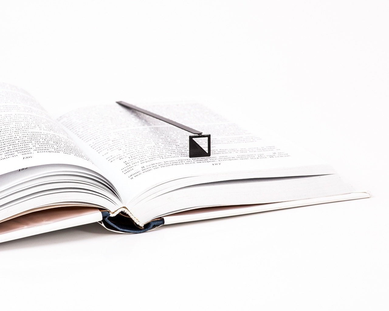 Half Square metal bookmark marking a page in an open book