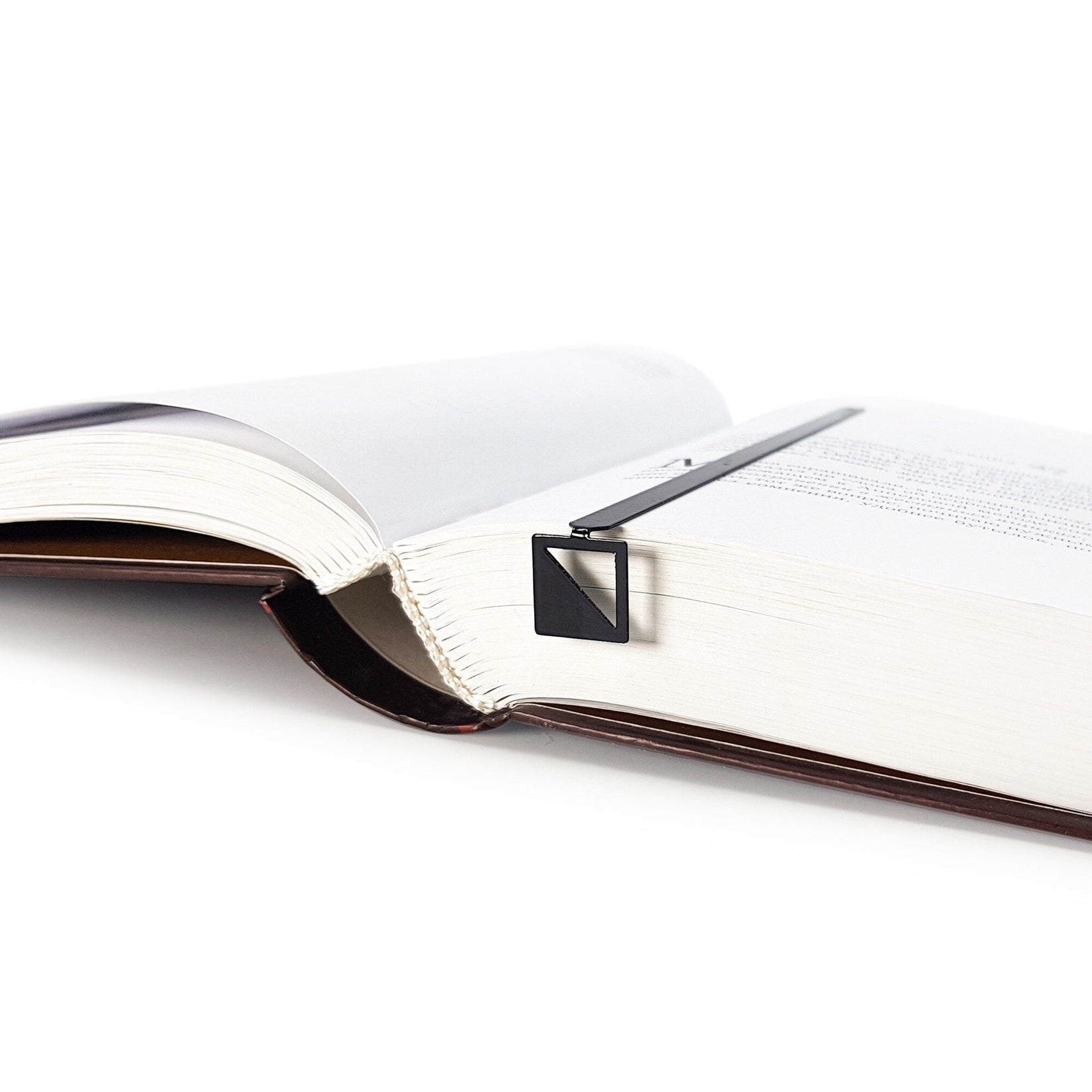 Half Square metal bookmark resting on the pages of an open book
