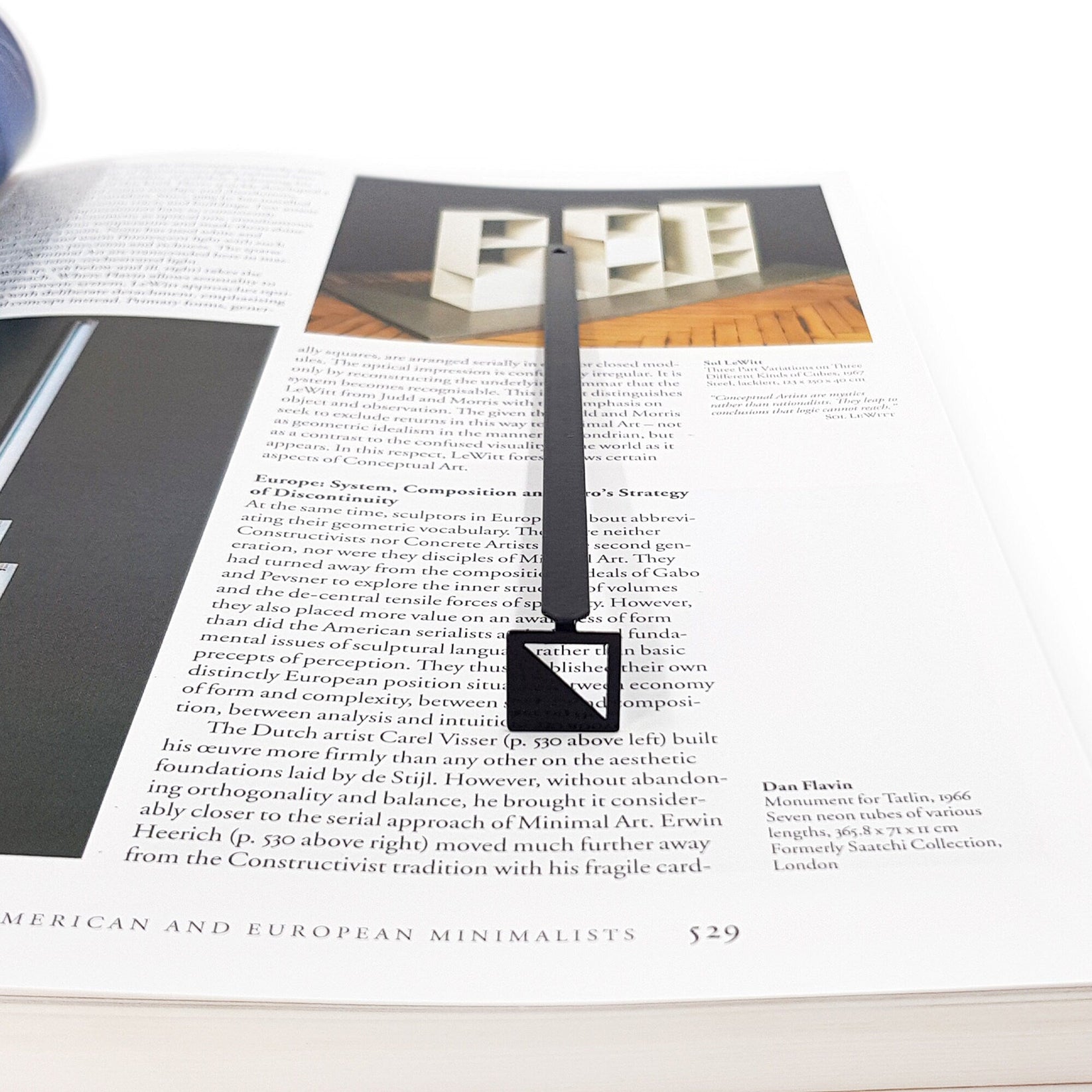 Half Square metal bookmark marking a page in an illustrated book