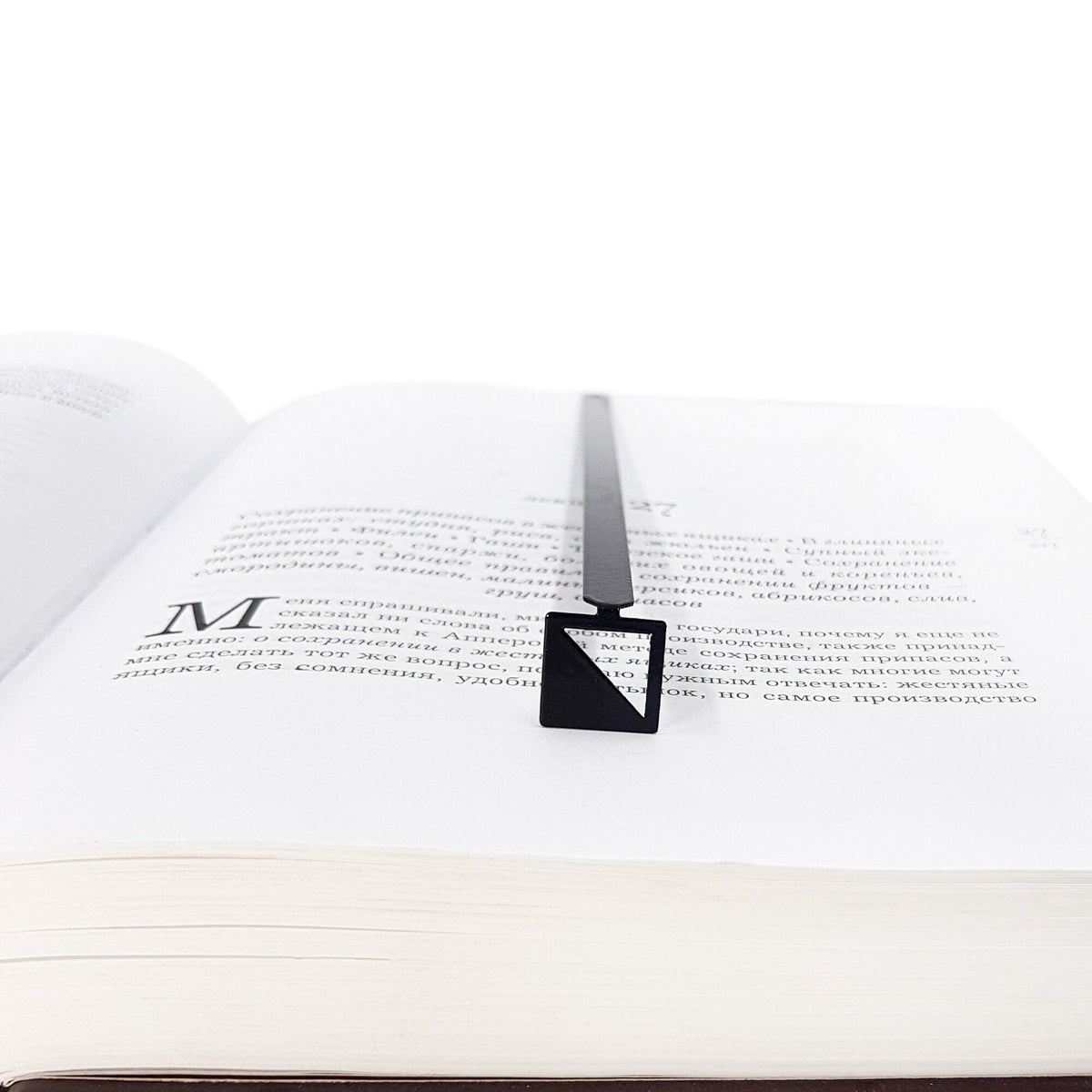 Half Square metal bookmark lying across the pages of an open book