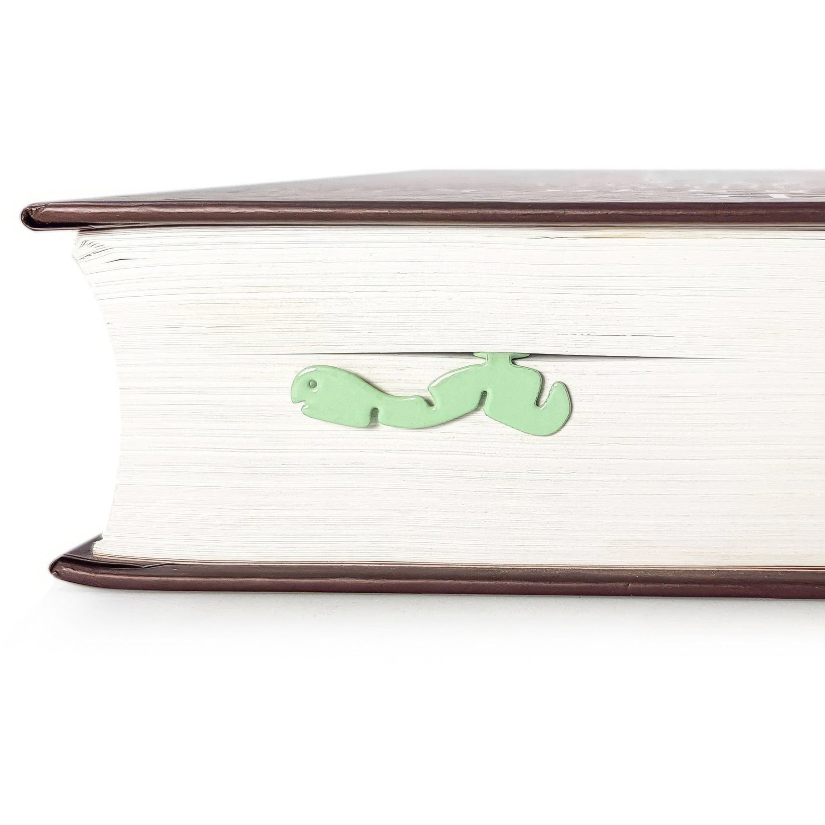 Happy metal bookmark in green seen from the edge of a closed book