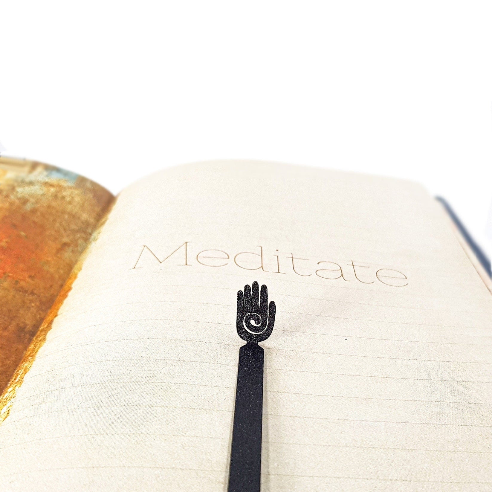 Healing Hand metal bookmark resting on the pages of an open book