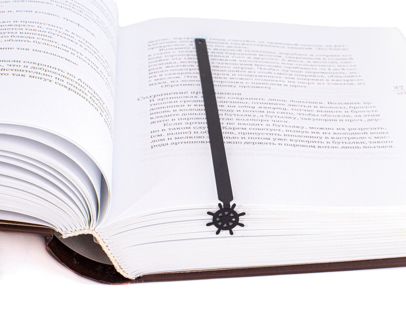 Helm metal bookmark marking a page in an open book