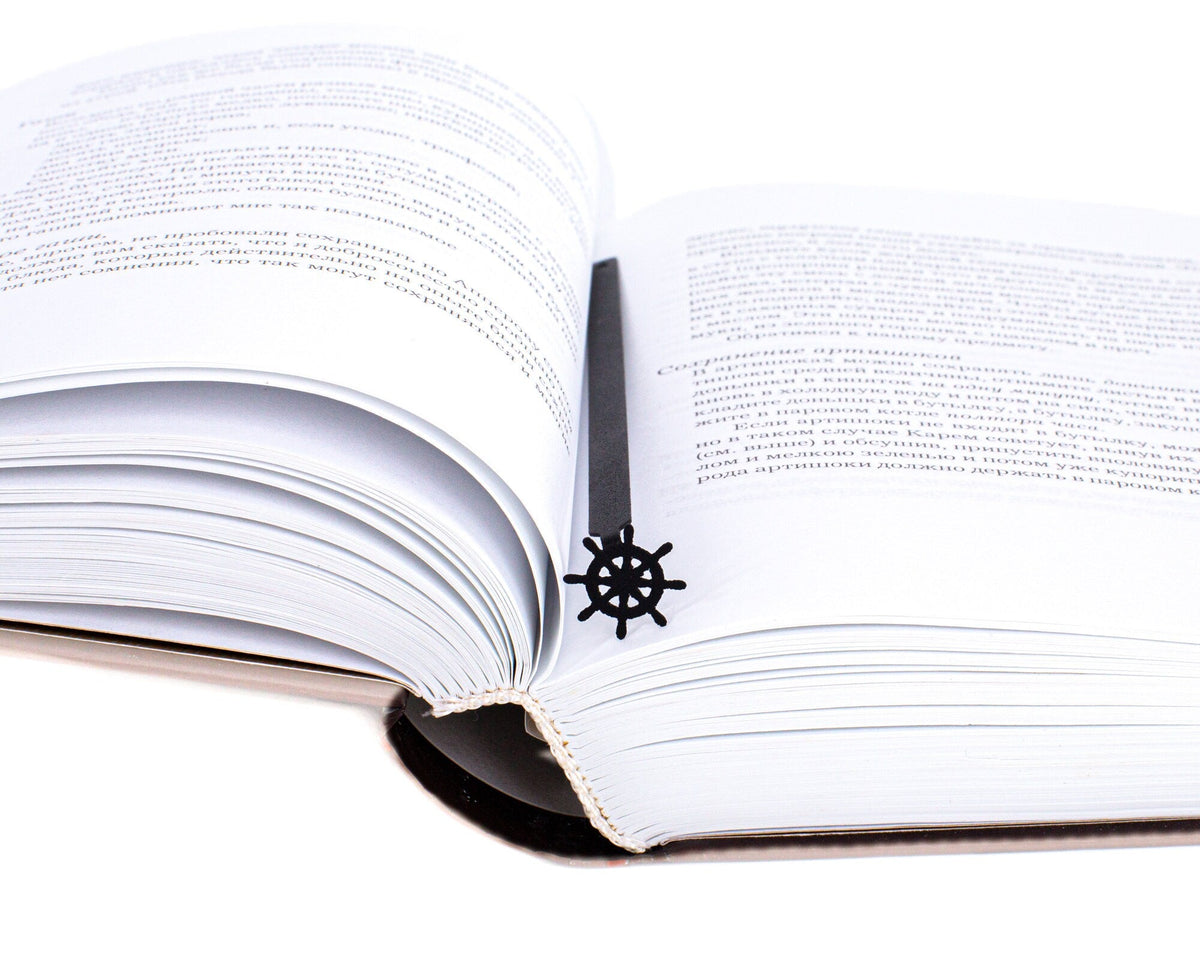 Helm metal bookmark lying across the pages of an open book