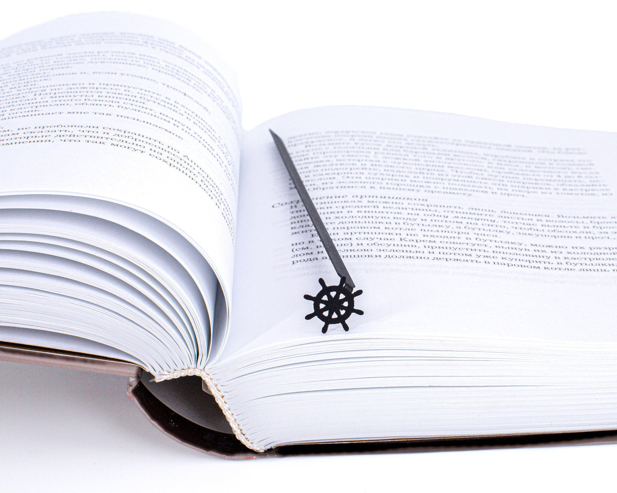 Helm metal bookmark resting on the pages of an open book