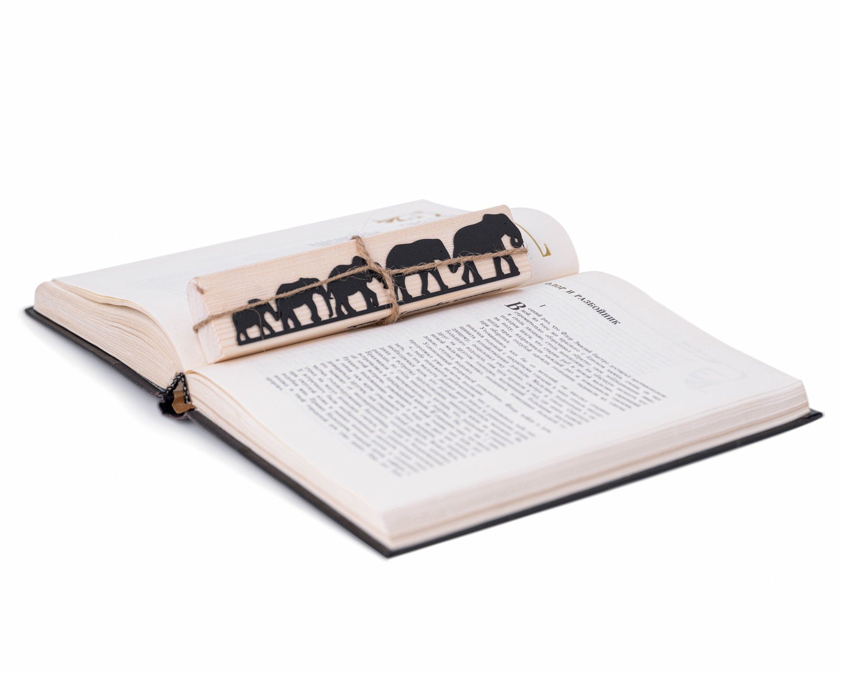 Herd of Elephants metal bookmark resting on the pages of an open book